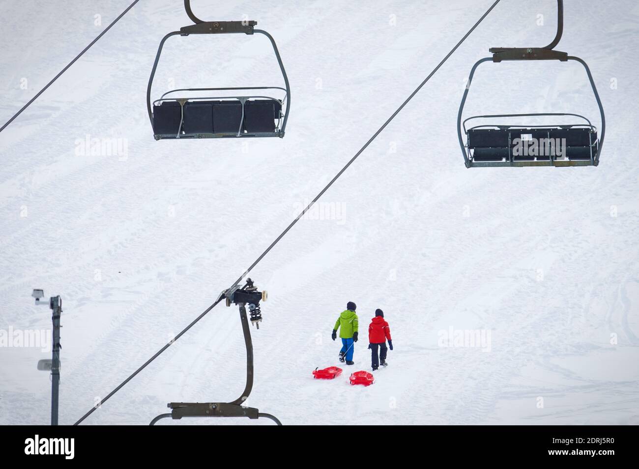 Skipisten wegen Pandemie über Weihnachten geschlossen, nur wenige Touristen mit Kindern spielen im Schnee mit Bob. Sestriere, Italien - Dezember 2020 Stockfoto