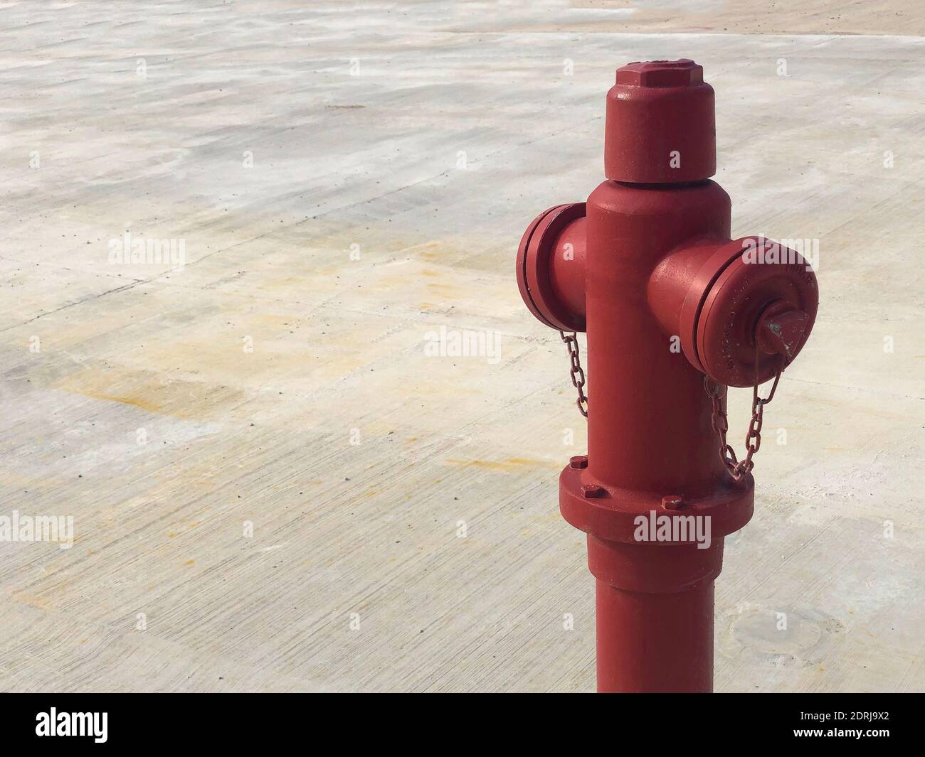 Roter Hydrant vor Betongrund. Feuerwehrausrüstung Stockfoto
