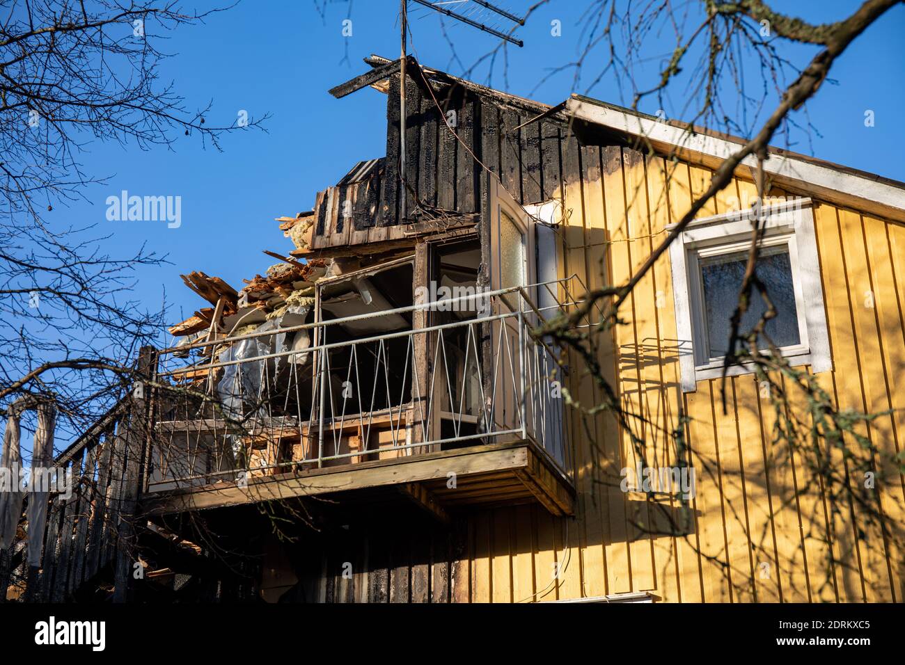 Verbranntes hölzernes Wohngebäude gegen blauen Himmel Stockfoto