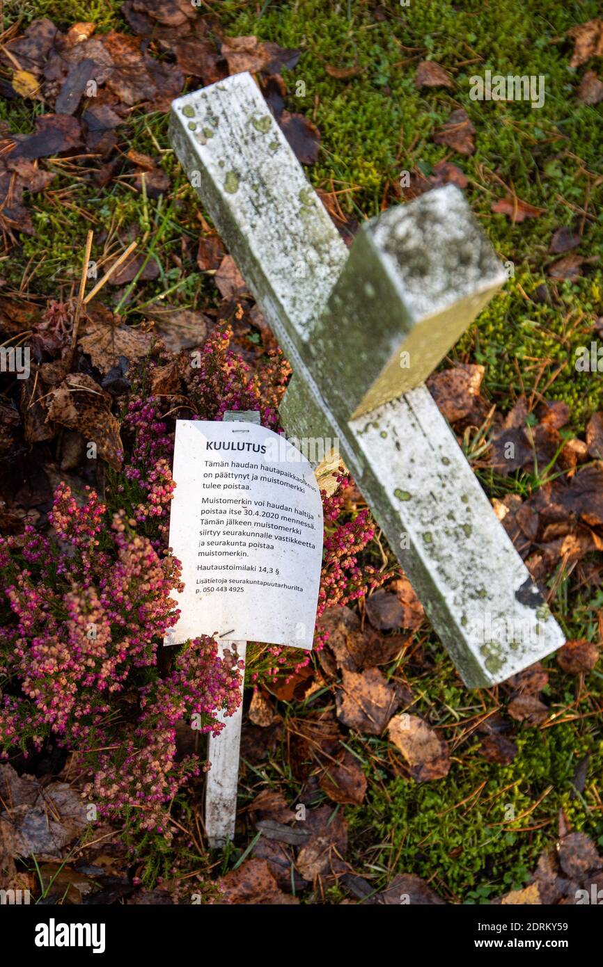 Räumungsnotiz neben Holzkreuz auf dem Friedhof in Finnland Stockfoto