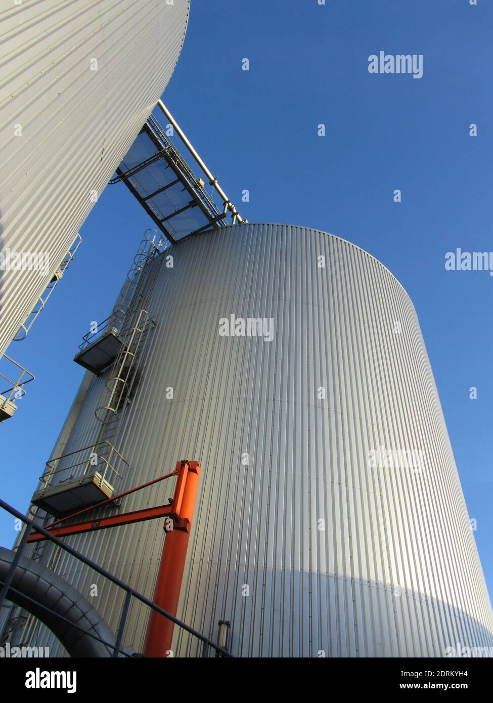 Zwei Biogas-Fermenter zeigen ihre beste Form in einem Blau Himmelslandschaft Stockfoto