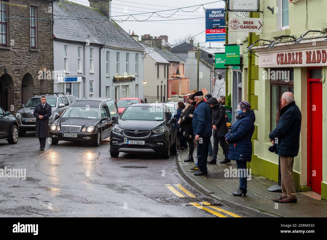 Timoleague, West Cork, Irland. Dezember 2020. Der Leichenwagen, der die Schatulle des Abenteurers Tim Severin trägt, durchquert sein Heimatdorf Timoleague, während Einheimische die Straße säumen, um ihren Respekt zu zollen. Herr Severin soll in Ringaskiddy, County Cork, eingeäschert werden. Quelle: AG News/Alamy Live News Stockfoto