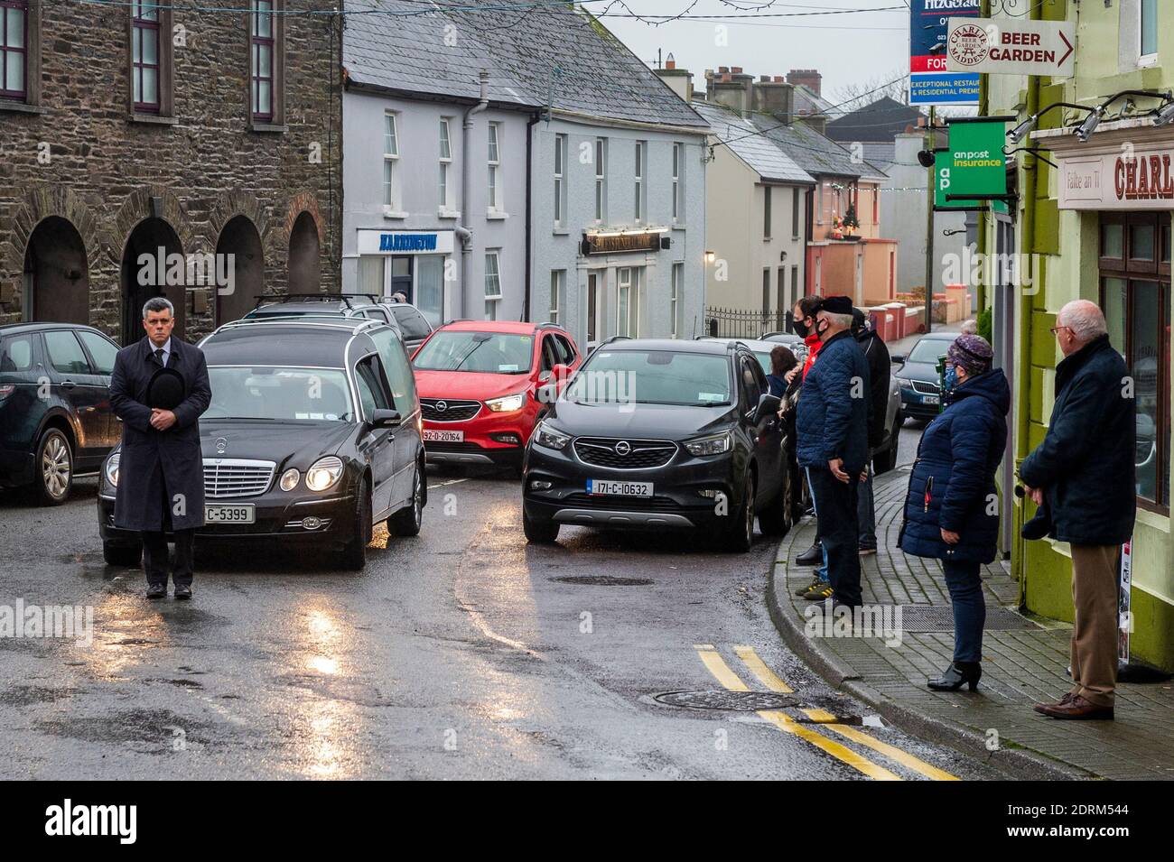 Timoleague, West Cork, Irland. Dezember 2020. Der Leichenwagen, der die Schatulle des Abenteurers Tim Severin trägt, durchquert sein Heimatdorf Timoleague, während Einheimische die Straße säumen, um ihren Respekt zu zollen. Herr Severin soll in Ringaskiddy, County Cork, eingeäschert werden. Quelle: AG News/Alamy Live News Stockfoto