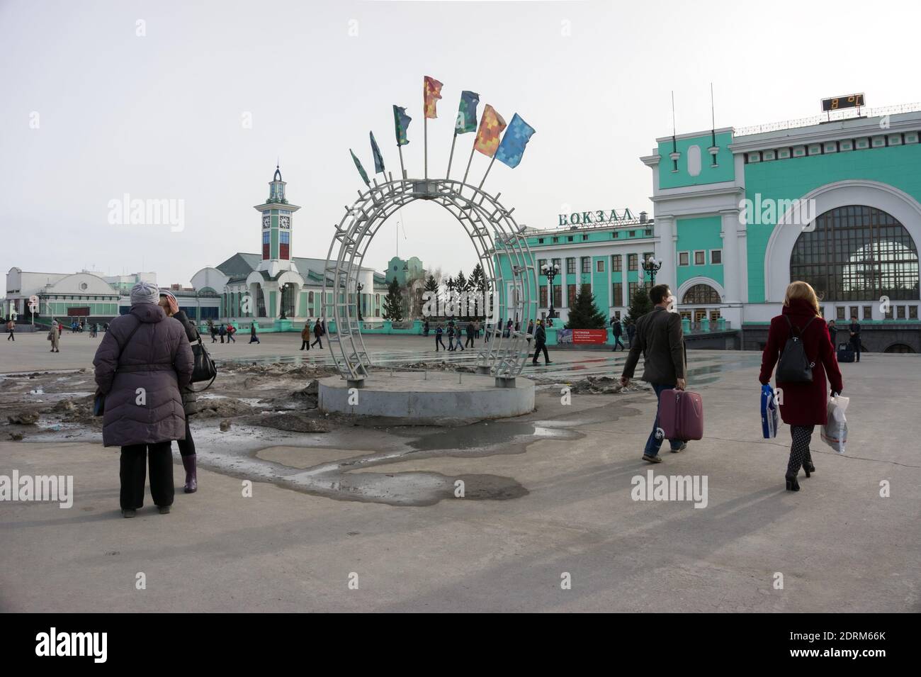 An einem wolkigen Frühlingstag stehen Menschen in der Nähe eines Metallbogens mit Fahnen auf dem Bahnhofsplatz des Hauptbahnhofs (1939). Stockfoto