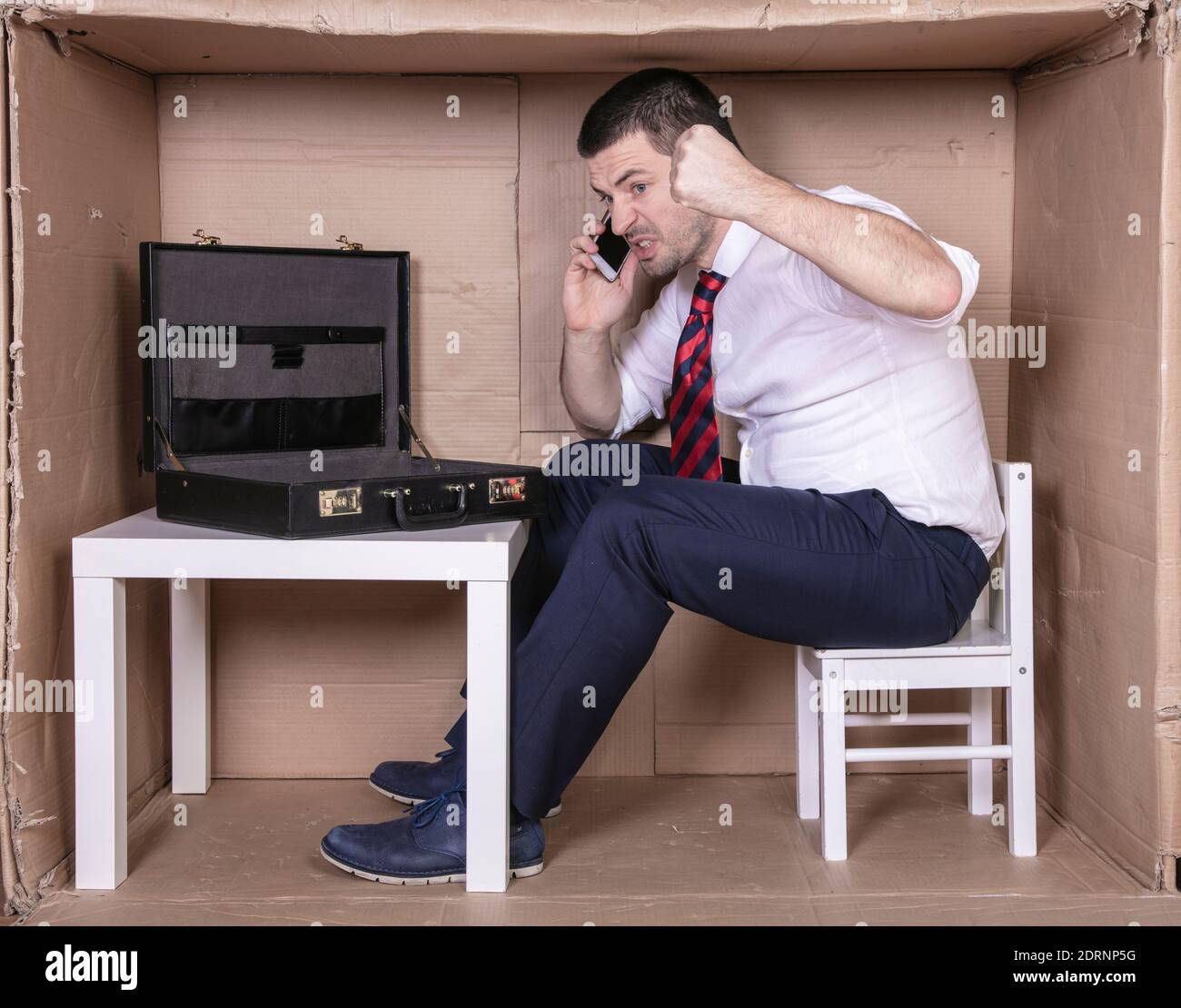 Harter Geschäftsmann, der am Telefon spricht Stockfoto
