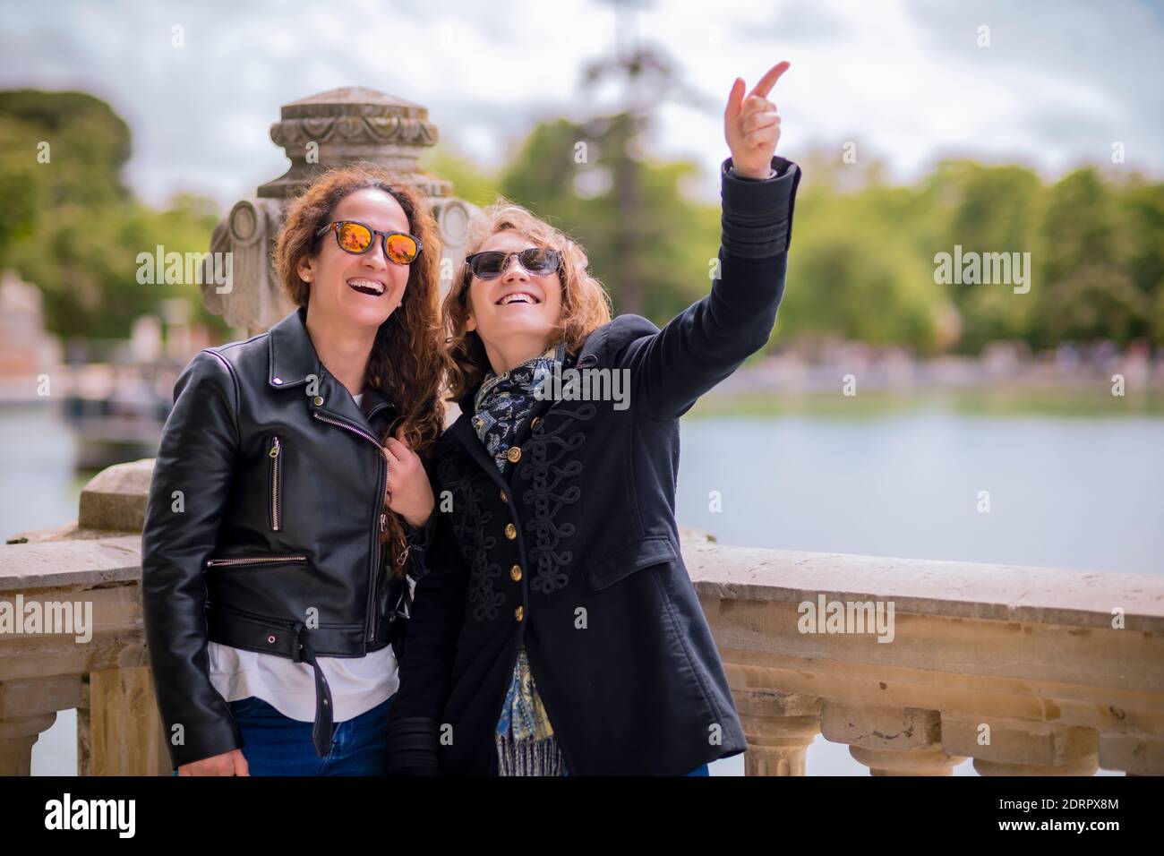 Zwei Frauen, die sich die Stadt ansehen, lächeln und schauen sich etwas an, das sie lustig macht. Stockfoto