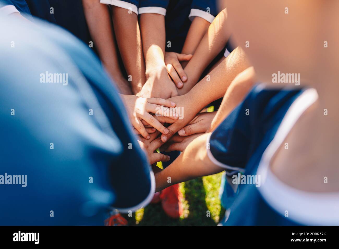 Gruppe von glücklichen Kindern im Sportteam Stapeln Hände im Freien in einem Sommertag. Kindermannschaftssport. Jungs im Sportlager stapeln Hände vor einem Spiel. Stockfoto