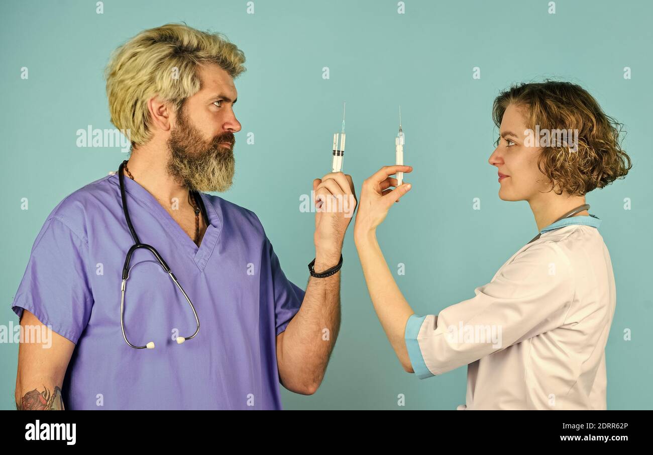 Die Spritze wird von Arzt und Pflegepersonal verwendet. Erfolgreiches Team von Ärzten. Menschen in Uniformen blauer Hintergrund. Medizinisches Personal. Vertrauen Sie unseren Profis. Gesundheitswesen, Teamarbeit und Mitarbeiterkonzept. Stockfoto