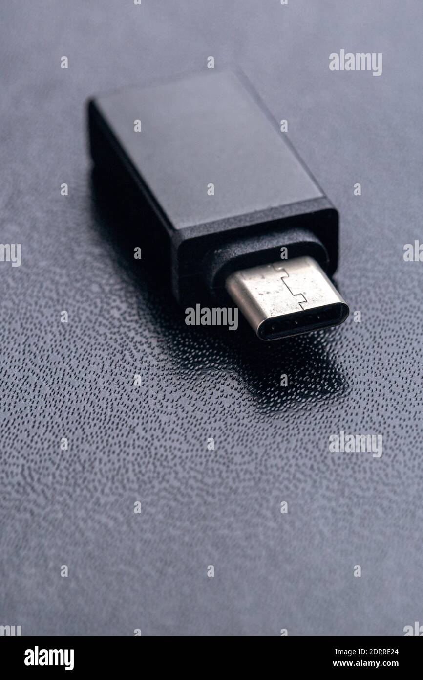 Schwarzes USB OTG (USB on the Go) Mit USB Typ C Anschluss für den Anschluss zwischen Handy und Flash-Laufwerk auf schwarzem Hintergrund Stockfoto