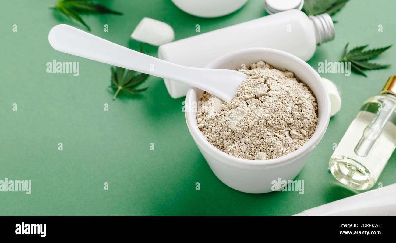 Gesichtsmaske aus Ton mit CBD-Cannabis infundiert und Set Hautpflegekosmetik in weißem Schlauch mit CBD-Öl, Serum in Tropf, Cannabis Blatt lange Web-Banneron Stockfoto