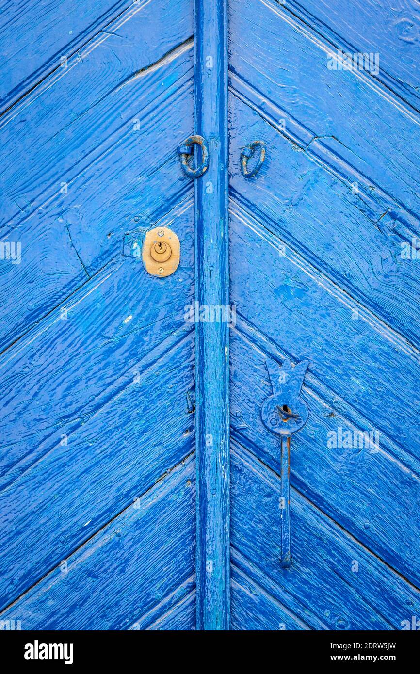 Geschlossene alte blaue Holztür, deutlich gealtert und zeitgewaschen. Stockfoto
