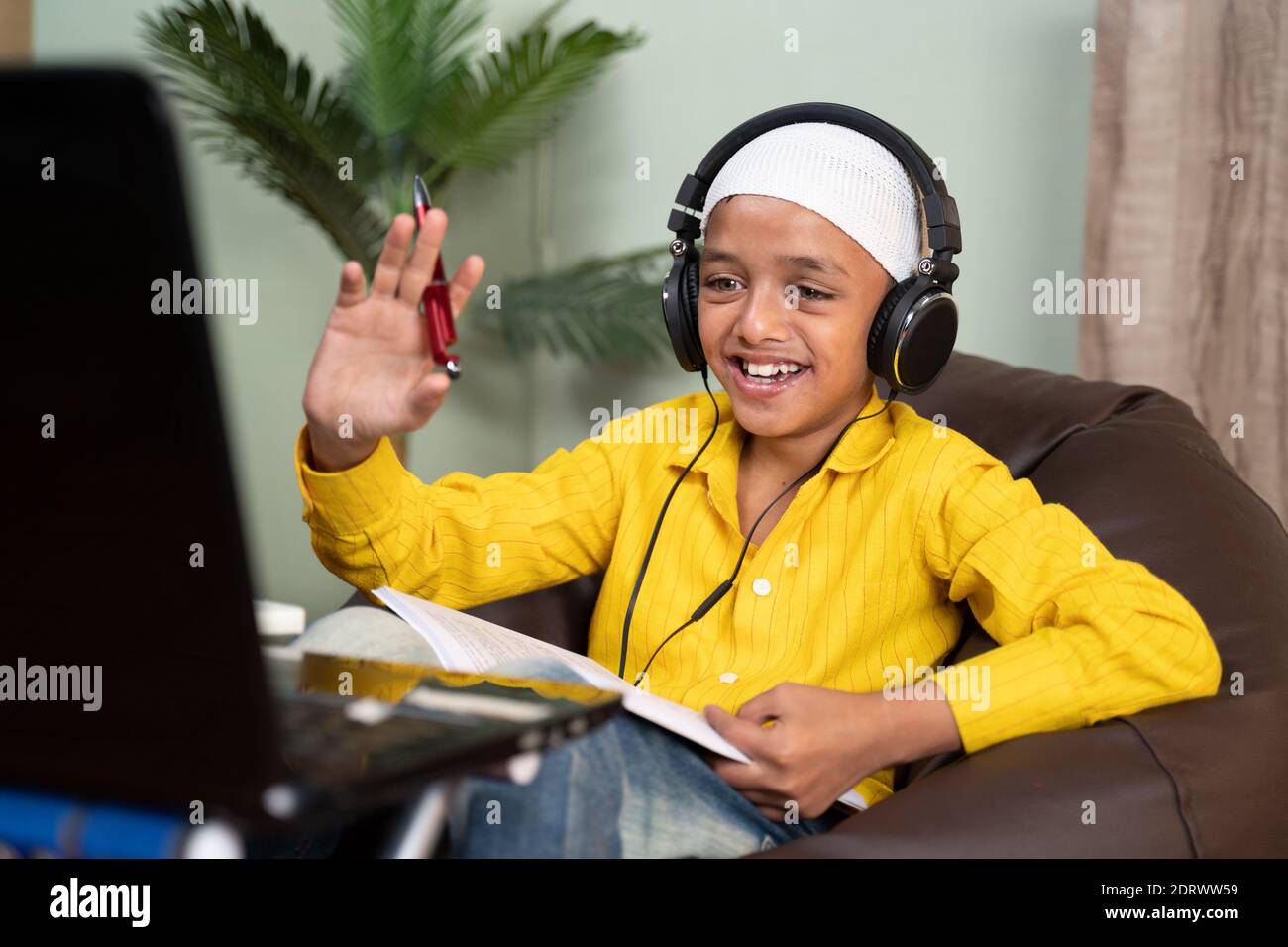 Muslimische Kind beschäftigt auf Online-Klasse, indem sie Videoanruf auf Laptop - Konzept der neuen normalen, E-Learning, virtuelle Bildung und zu Hause Schulbildung aufgrund Corona Stockfoto