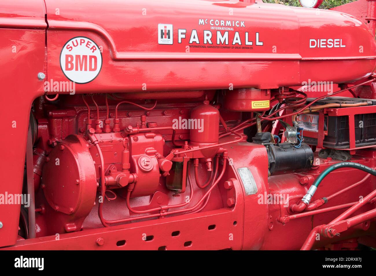 Name auf der Motorabdeckung eines restaurierten und neu lackierten roten International Harvester Farmall Super BMD Vintage Traktors auf einer Messe in Nordostengland, Großbritannien Stockfoto