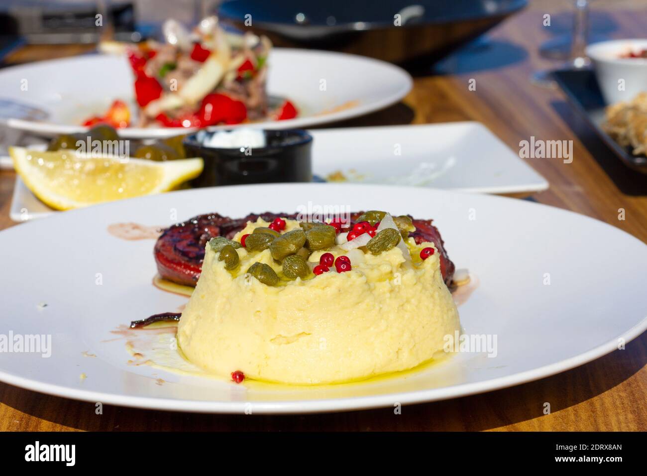 Traditionelle griechische Fava (gelbes, geteiltes Erbsenpüree), lokales Produkt der Insel Santorini, und gegrillter Oktopus, köstliche Geschmäcke von Santorini, Griechenland. Stockfoto