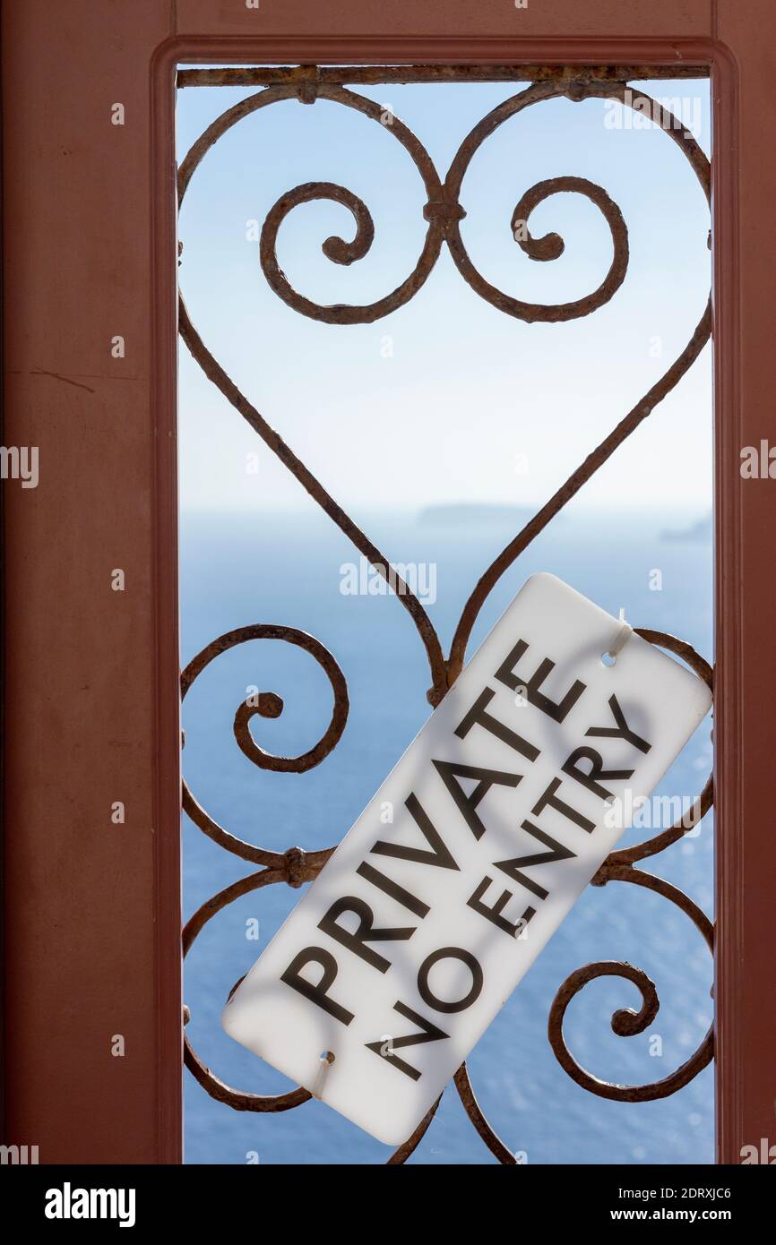 "Private - No Entry"-Schild an einer Holztür mit herzförmigen Bars, die Besucher darüber informieren, dass der Eintritt nur nach Ermessen des Besitzers erlaubt ist. Stockfoto