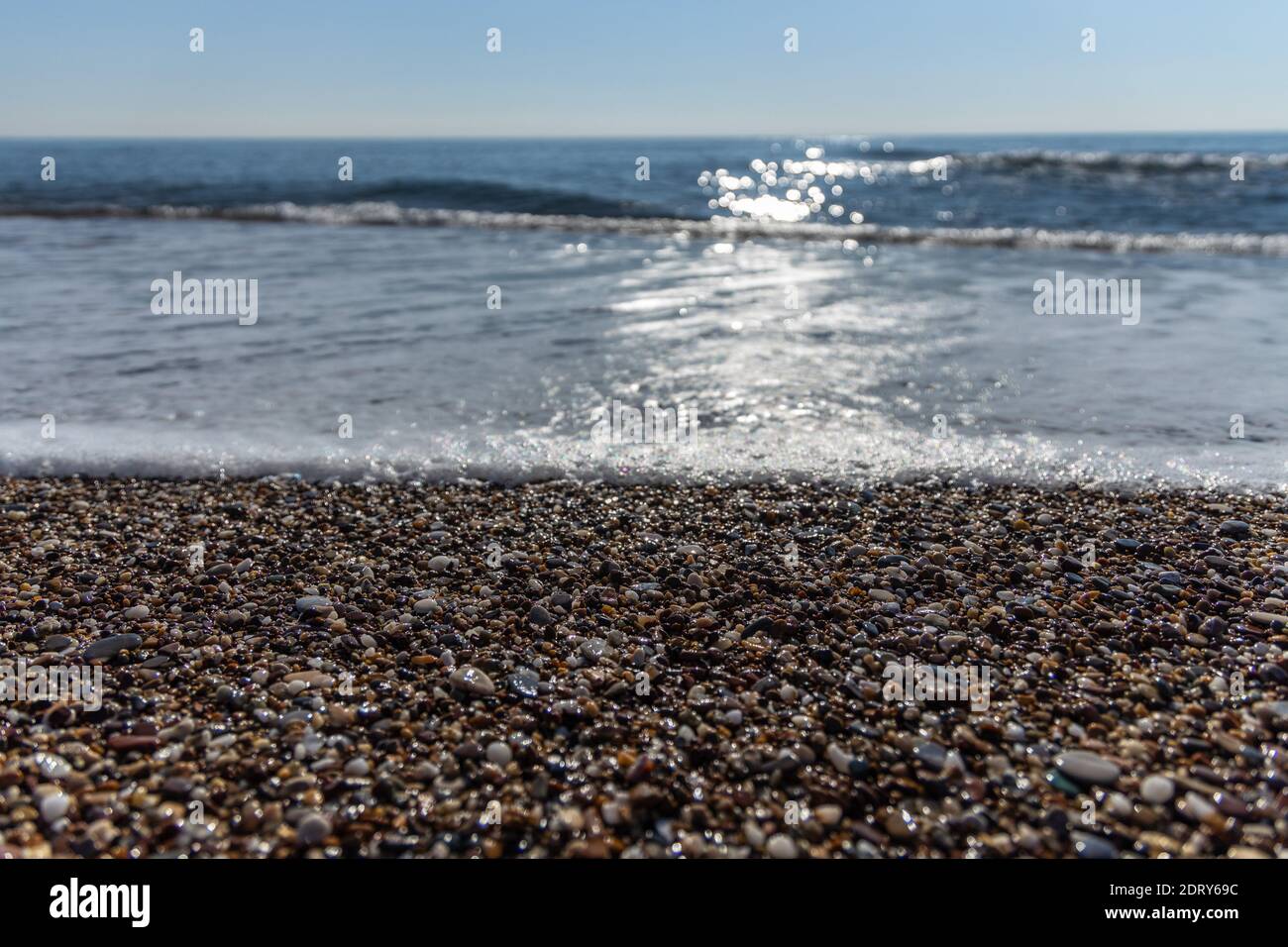 Funkelnde Wellen am Strand trifft den Kiesstrand in Antalya Türkei, Urlaubs- und Reisekonzept, sonniger und blauer Himmel, niemand, keine Menschen, Platz für tex Stockfoto