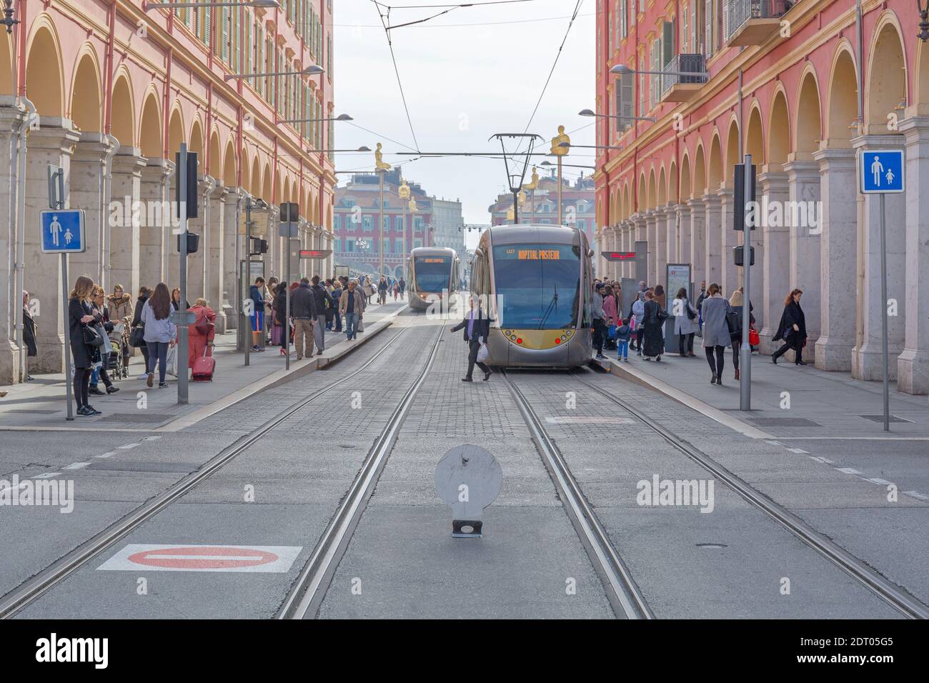 Nizza, Frankreich - 3. Februar 2016: Elektrische Straßenbahnen und Pendler am Bahnhof Platform in Nizza, Frankreich. Stockfoto
