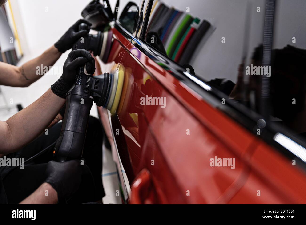 Auto detailliert Studio Arbeiter Entfernen von Kratzern und Polieren Auto Stockfoto