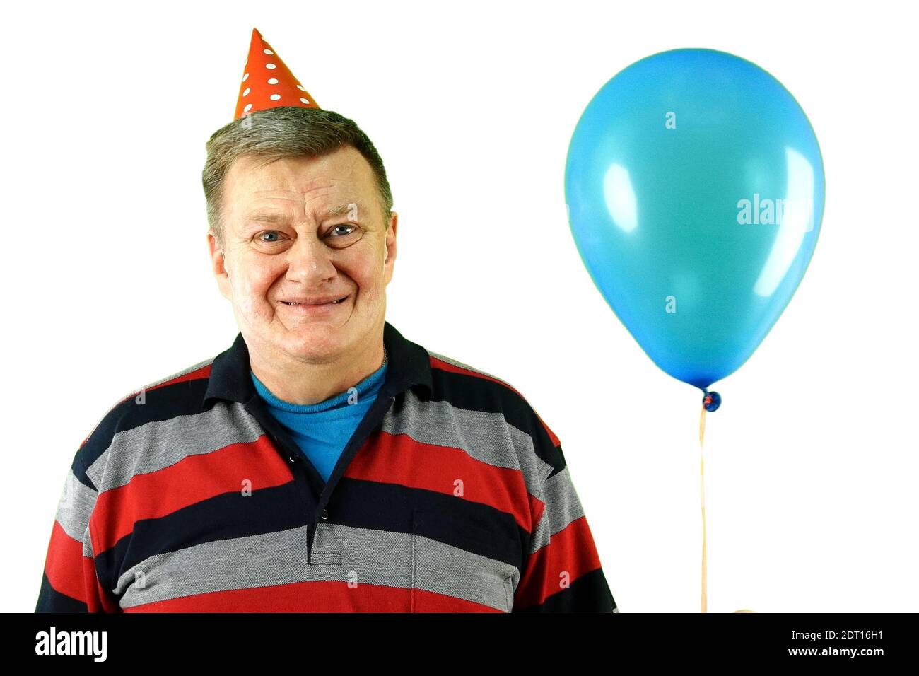 Reifer erwachsener Mann kaukasischer Ethnie in lässiger Kleidung und Geburtstagsmütze mit Luft Helium Ballon, lächelnd und frohlockend. Auf weißem Hintergrund ausschneiden Stockfoto