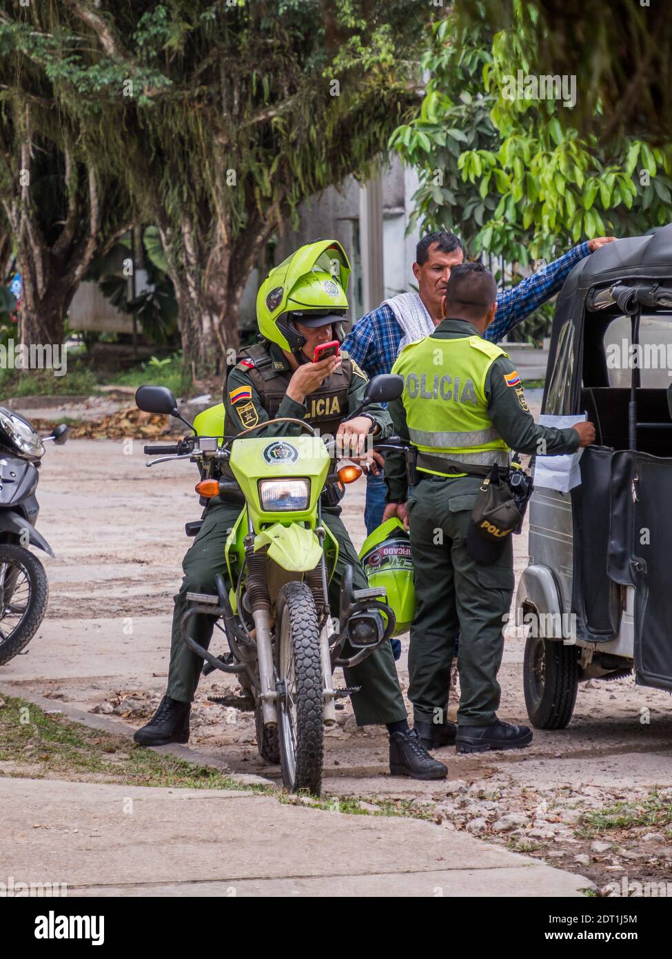 Leticia, Kolumbien - 21. Dezember 2019: Polizisten kontrollieren ein Auto auf der Straße einer tropischen Stadt im Amazonas. Policia. Südamerika. Stockfoto