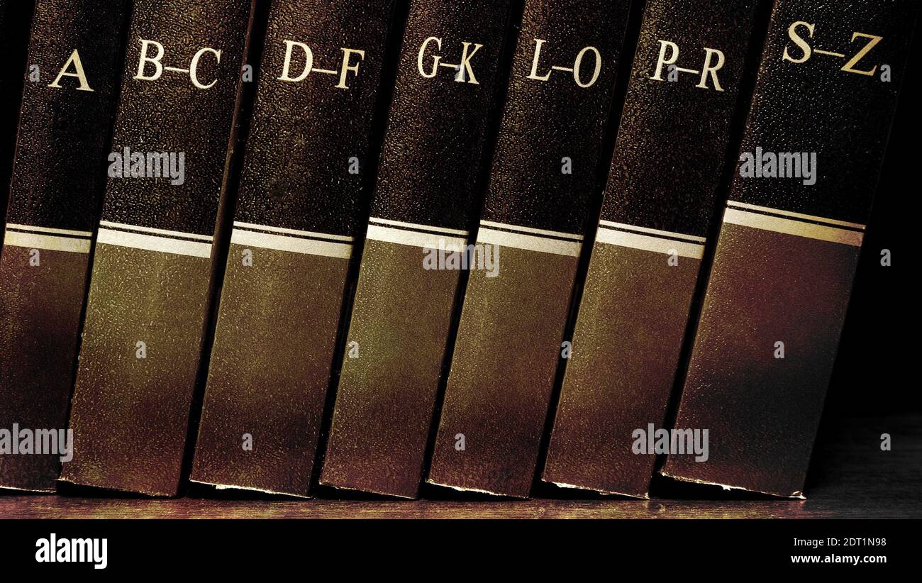Reihe von alten Lederbüchern auf einem Regal mit Alphabet Stockfoto