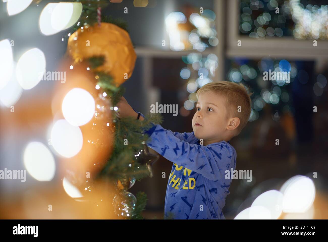 Kind dekoriert Weihnachtsbaum zu Hause in der Nacht Stockfoto