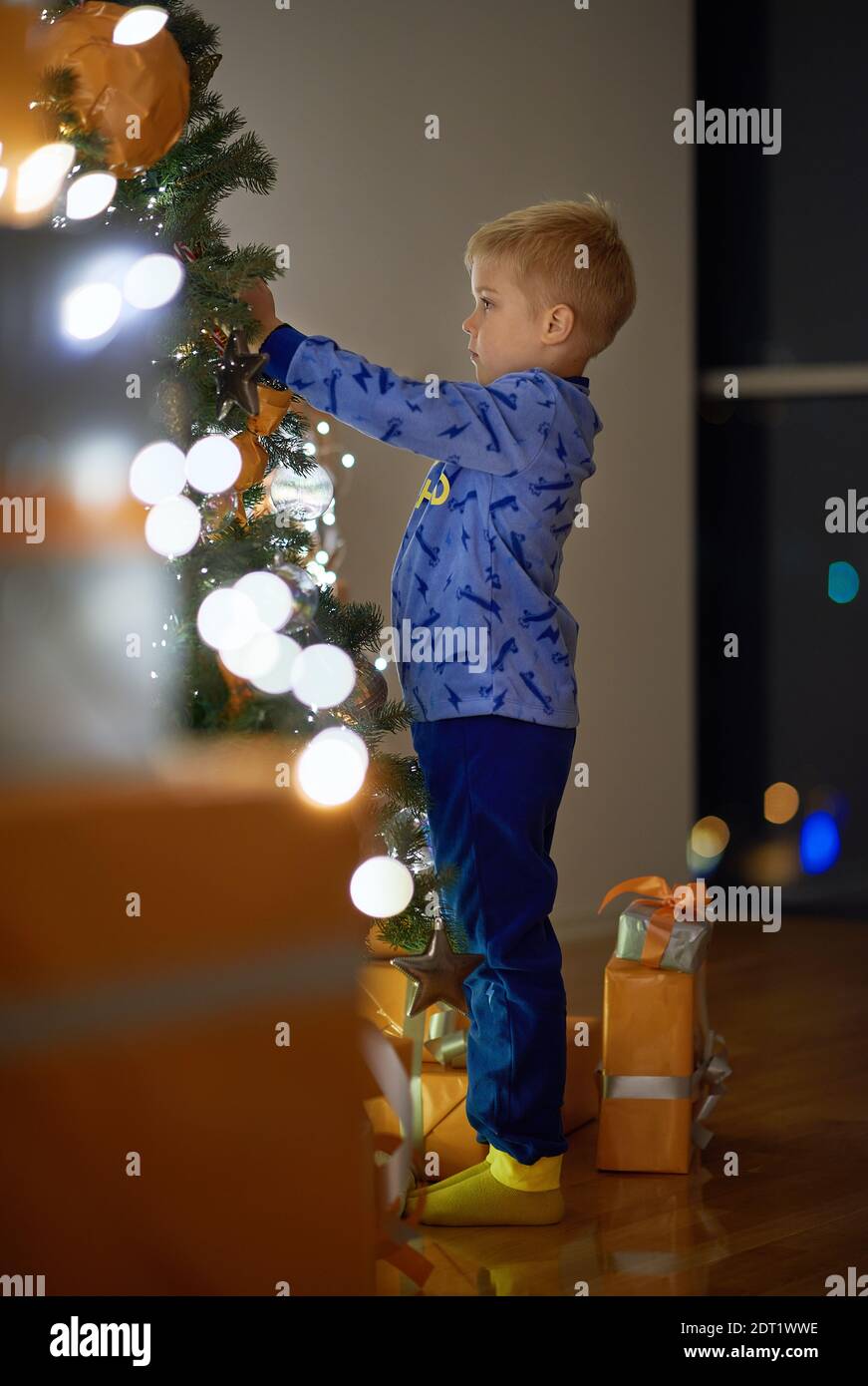 Kind dekoriert Weihnachtsbaum zu Hause in der Nacht Stockfoto