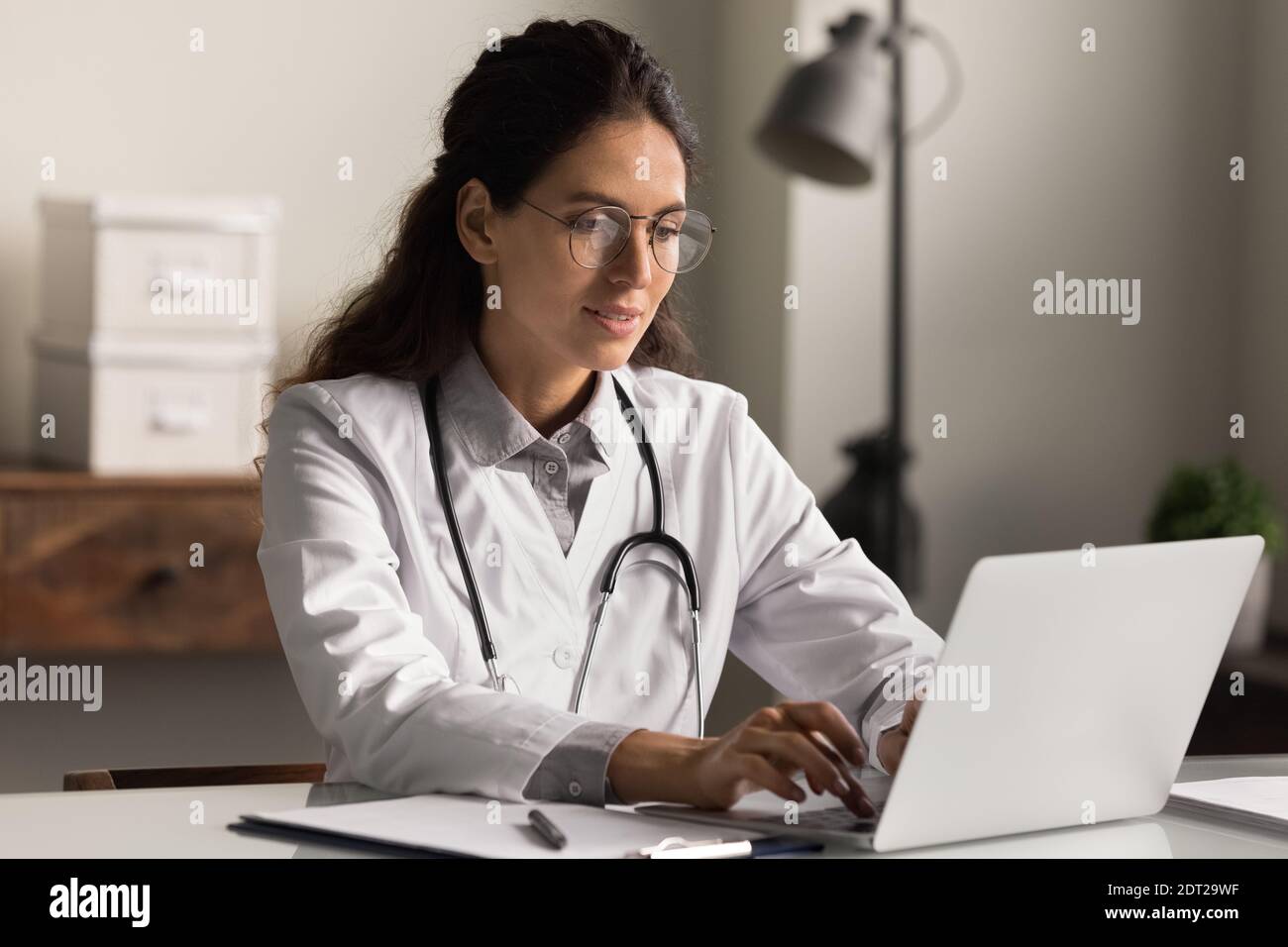 Lächelnde Ärztin arbeitet am Computer im Krankenhaus Stockfoto