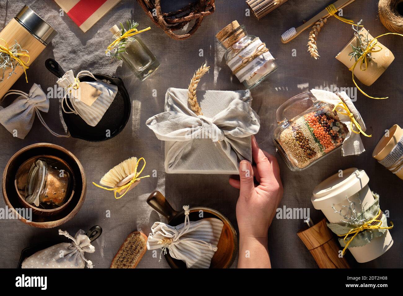 Weihnachtsgeschenke ohne Verschwendung. Geschichtete Einmachglas, Tassen, Kolben, Bürsten, Tassen und Schalen. Umweltfreundliche Geschenke ohne Plastik. Festlicher Hintergrund auf tren Stockfoto