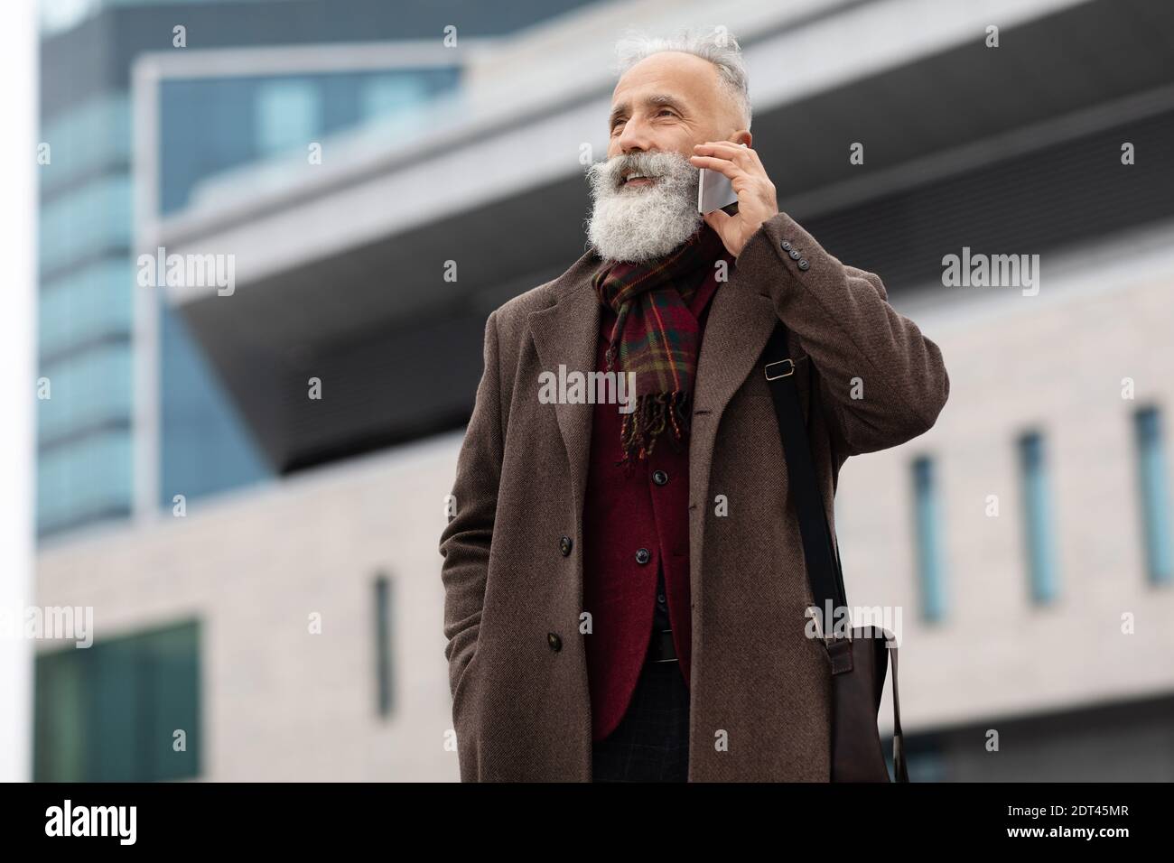 Wohlhabender älterer Mann, der im Freien telefoniert Stockfoto