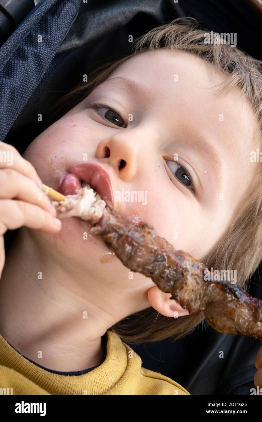 Vorderansicht eines Jungen, der Essen isst und die Kamera anschaut Stockfoto