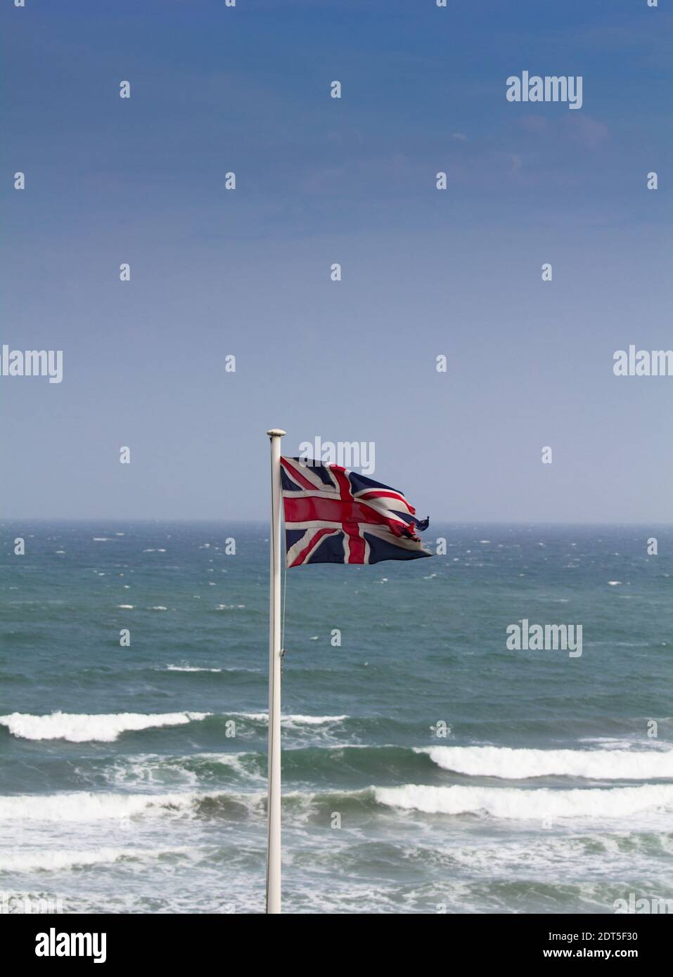 Union Flagge in einem starken Onshore-Wind mit Blick auf den Ärmelkanal, und eine mögliche Ansammlung Sturm. Stockfoto