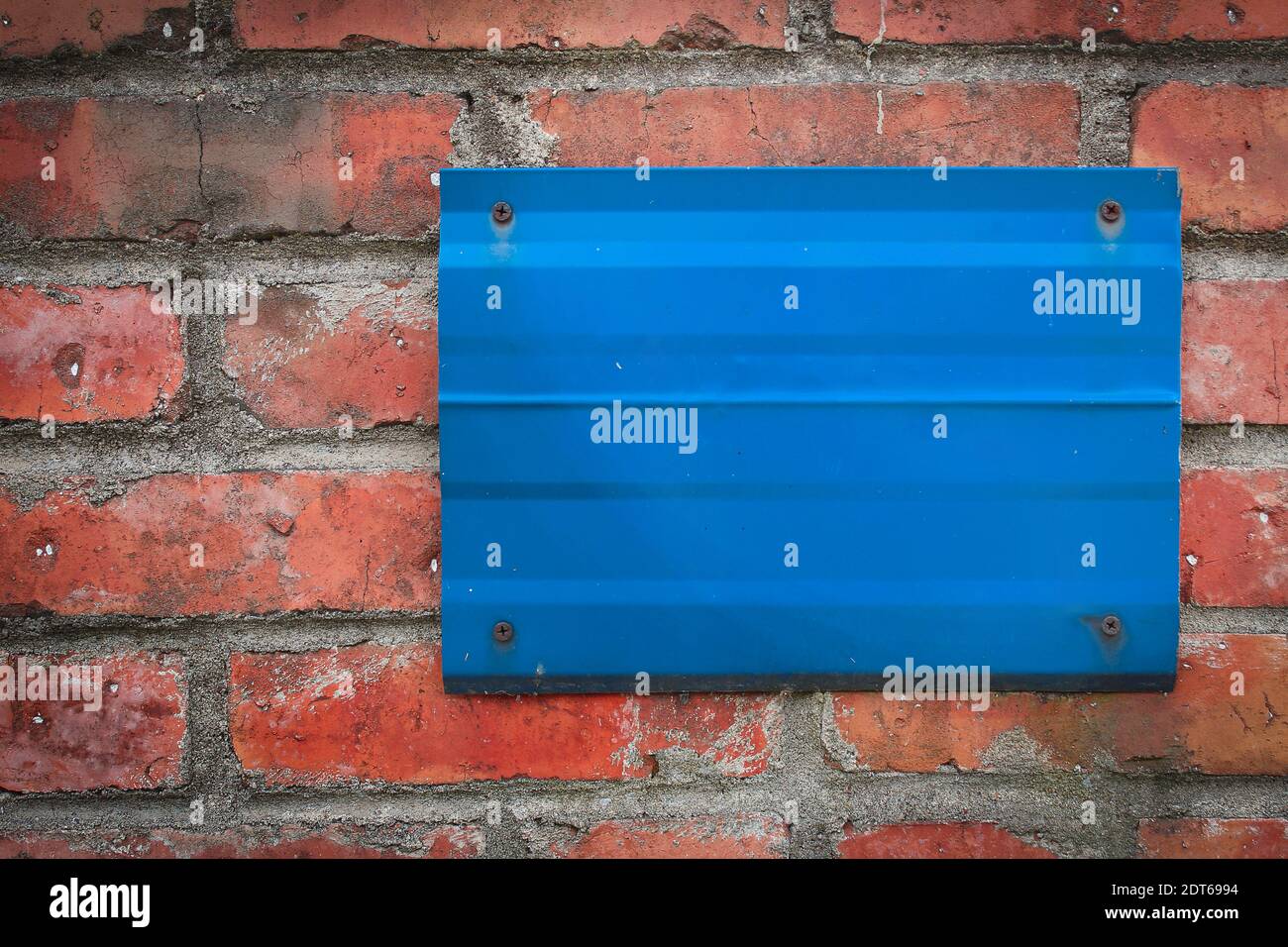Blaues Metallschild auf roter Ziegelwand mit Ziffer 21, Polen. Stockfoto