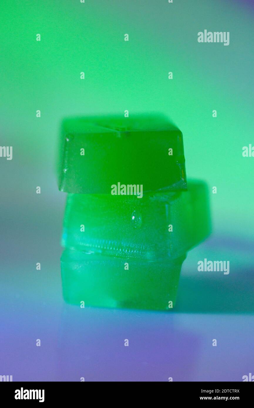 Stapel von essbaren Cannabisgummis in grünem Licht Stockfoto