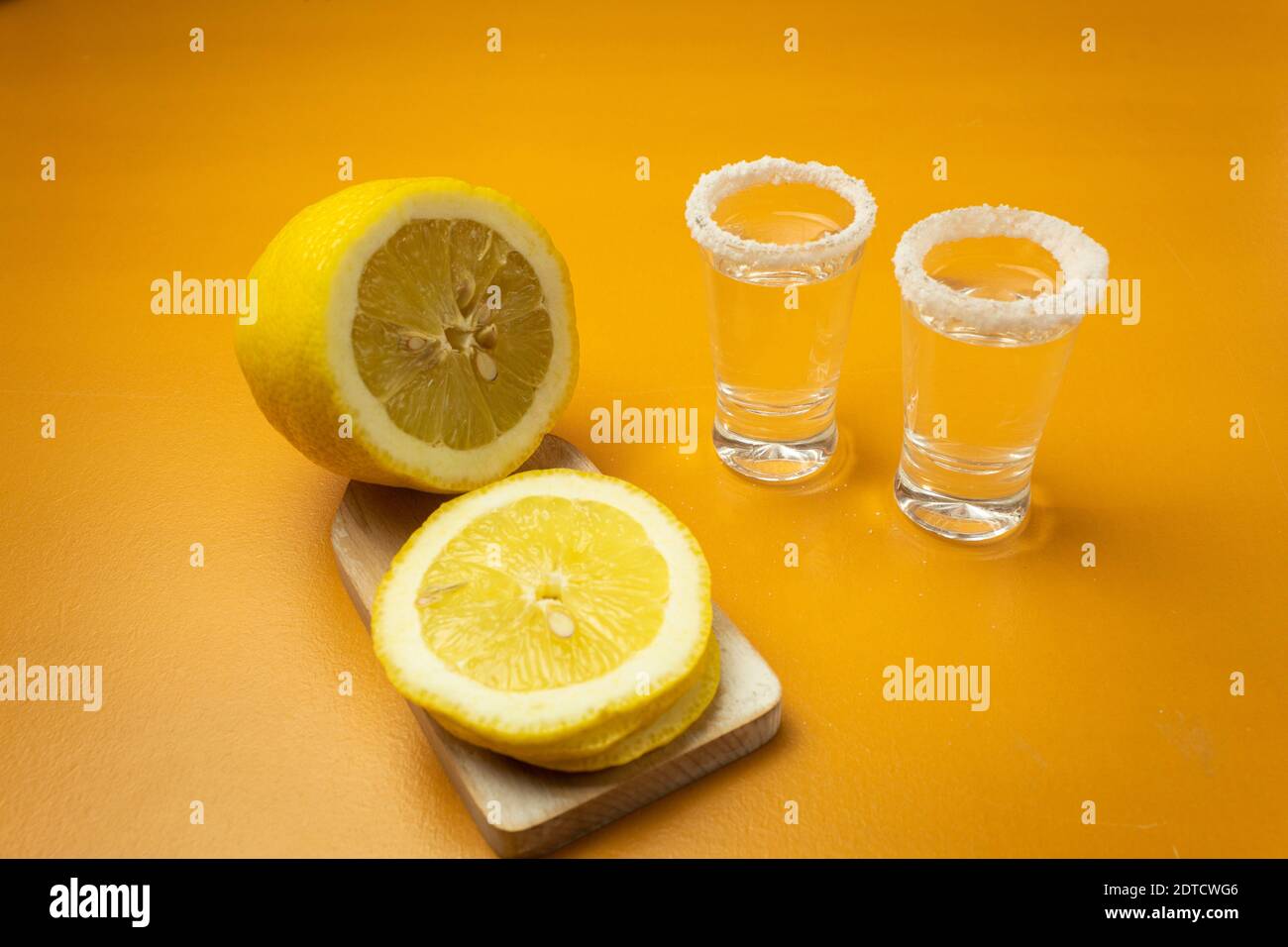 Tequila, Salz und Zitrone auf gelbem Grund. Seitenansicht. Stockfoto