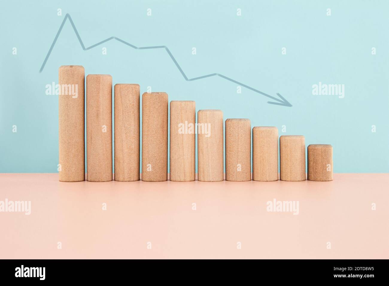 Holzblockdiagramm Histogramm oder Infografiken Balkendiagramm mit Pfeil nach unten in blauem Hintergrund, Finanz- und Wirtschaftskrise Konzept mit Kopierraum Stockfoto