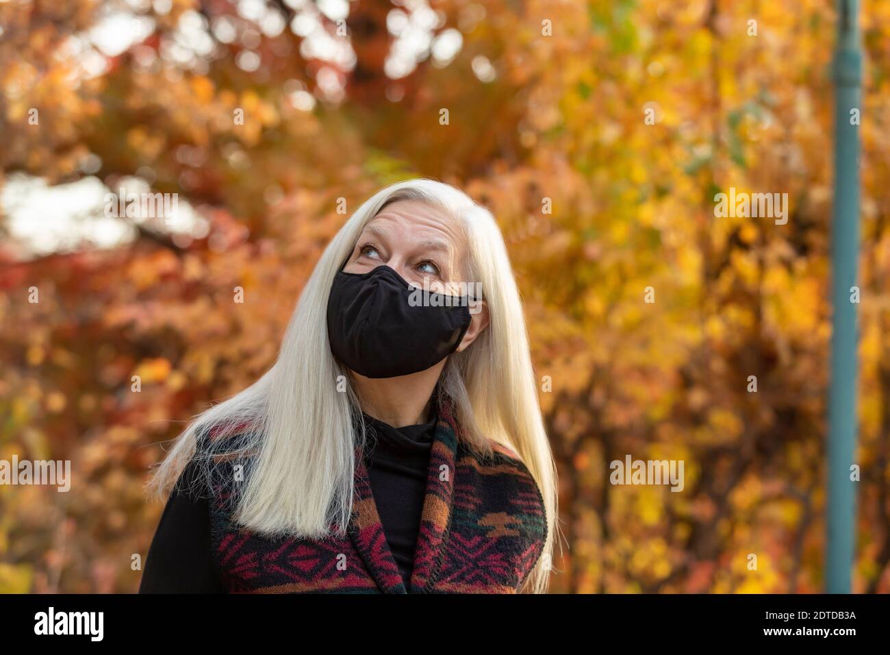 Porträt von älteren Frau trägt Covid Schutzmaske im Freien in Fallen Stockfoto