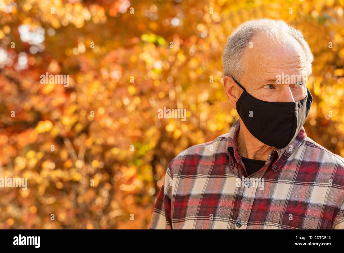 Porträt von älteren Mann trägt Covid Schutzmaske im Freien in Fallen Stockfoto