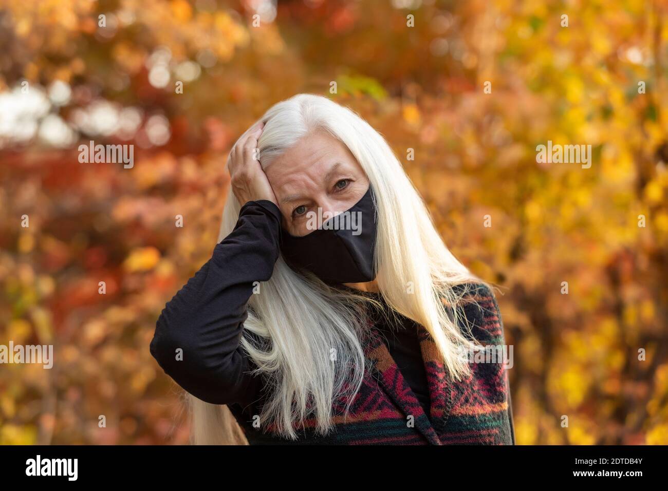 Porträt von älteren Frau trägt Covid Schutzmaske im Freien in Fallen Stockfoto