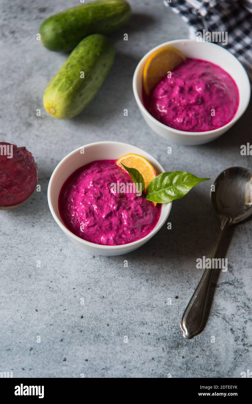 Draufsicht auf Rote Beete Dip serviert in zwei kleinen Schüsseln zusammen mit Gemüsewürzen auf einem Hintergrund. Stockfoto