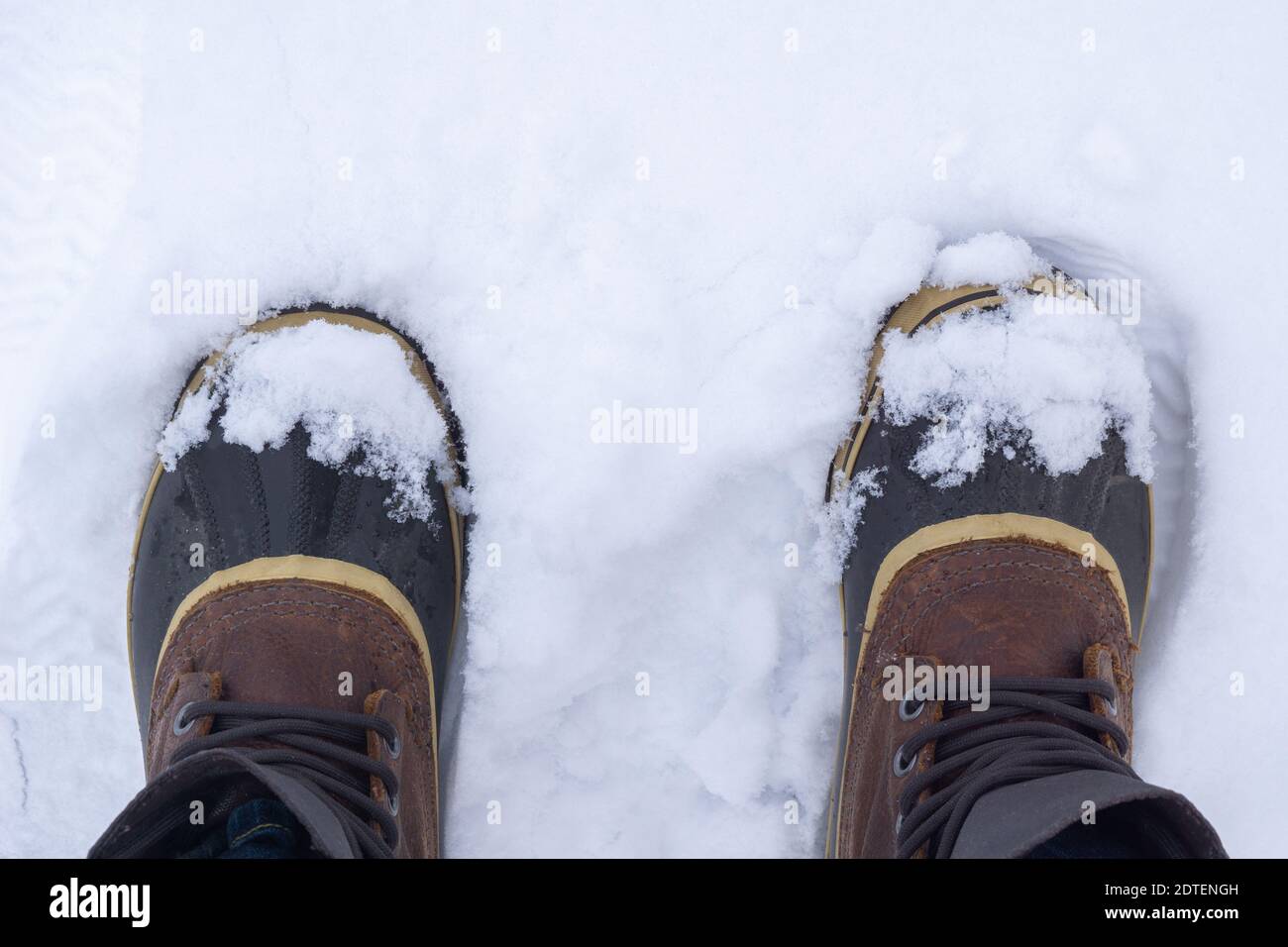 Draufsicht auf anonymen Reisenden in warmen Stiefeln stehen auf weißem Schnee am Wintertag. Stockfoto