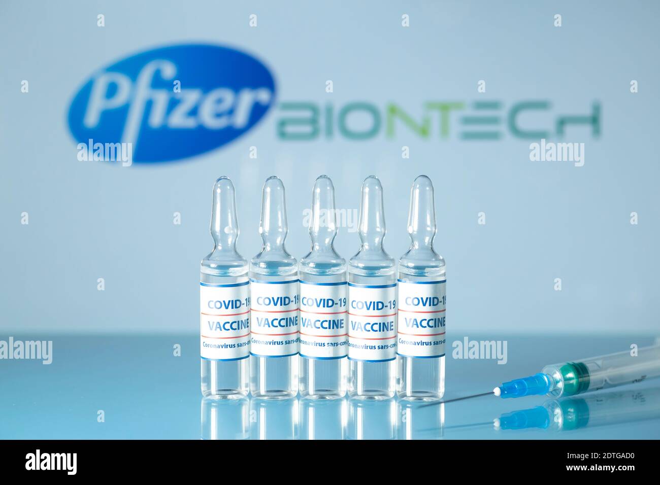 Pfizer- und BioNtech-Impfstoff gegen COVID-19. Medizinische Glasfläschchen mit Flüssigkeit auf dem Hintergrund Pfizer und BioNtech Logo. Ampullen mit Coronavirus va Stockfoto