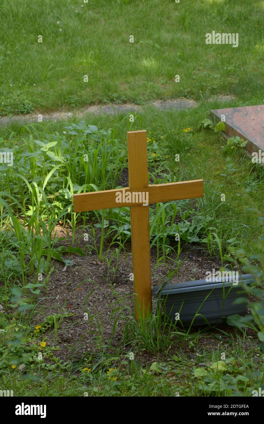 Neues hölzernes Kreuz auf einem anonymen Grab im Schatten Friedhof Stockfoto