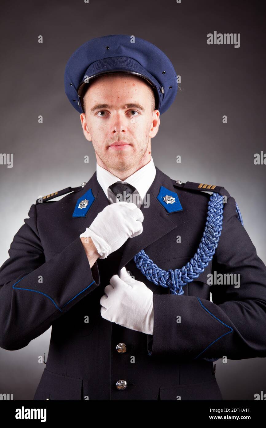 Eleganter Soldat in Uniform im Studio mit Pistole Stockfoto