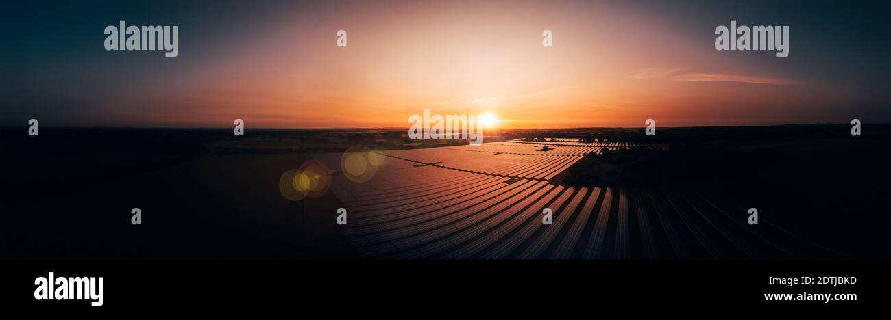 Luftaufnahme über eine moderne Solarfarm bei Sonnenaufgang in Die englische Landschaft Panorama Stockfoto
