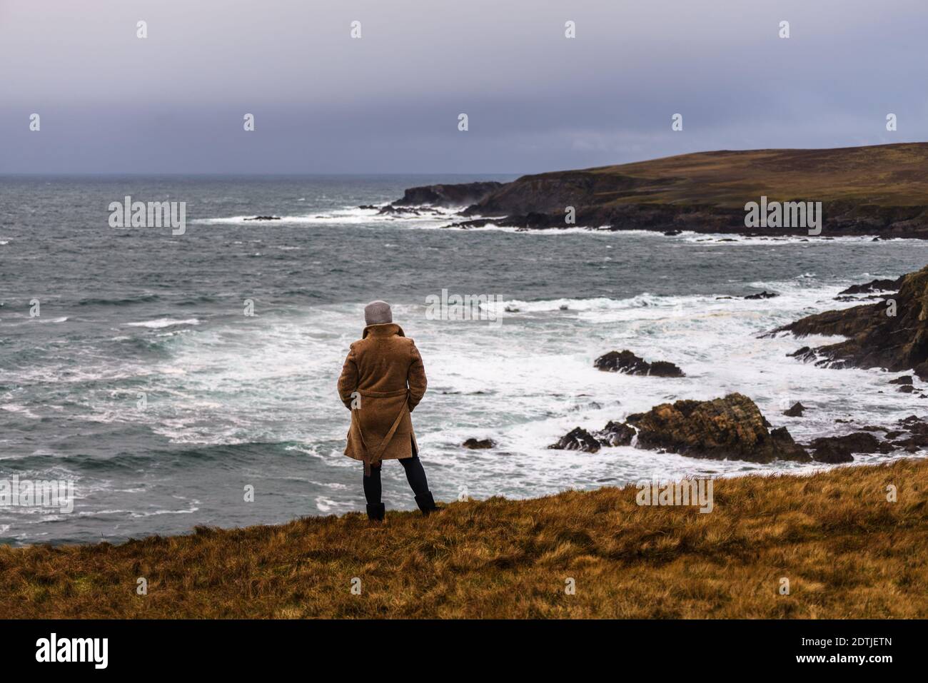 Die Frau, die den Blick auf den atlantischen Ozean Sturm am Ufer von Malin Beg genießt, kleines Dorf Gaeltacht südlich von Glencolumbkille, Grafschaft Donegal, Irland Stockfoto