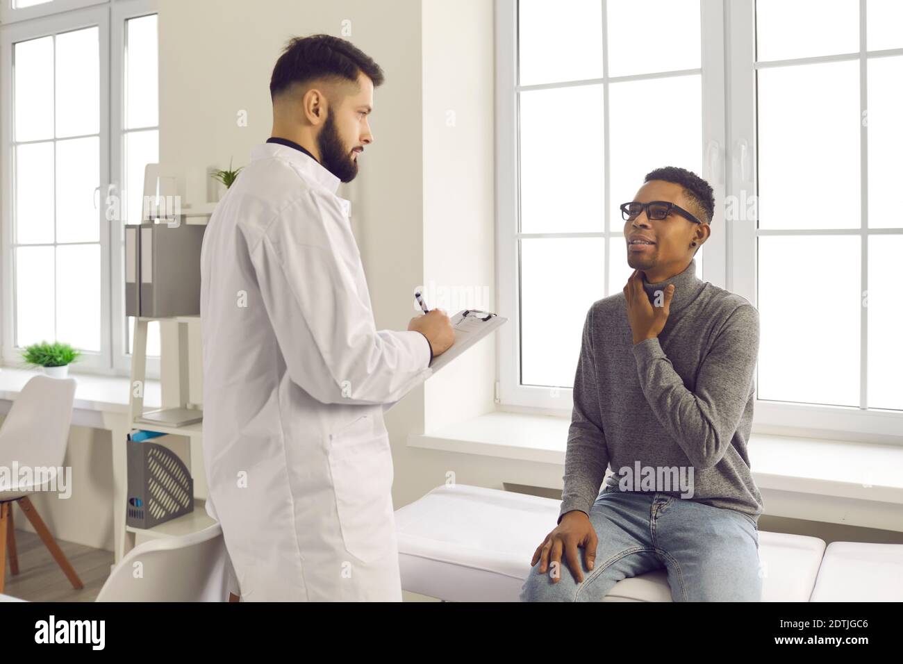 Patient beschwert sich beim Arzt über Halsschmerzen und Husten während Besuch im Krankenhaus Stockfoto