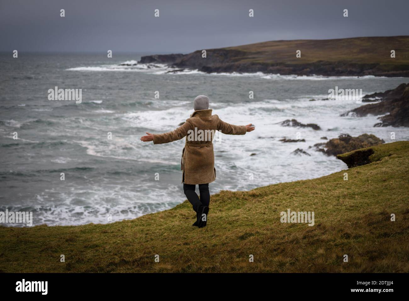 Die Frau, die den Blick auf den atlantischen Ozean Sturm am Ufer von Malin Beg genießt, kleines Dorf Gaeltacht südlich von Glencolumbkille, Grafschaft Donegal, Irland Stockfoto