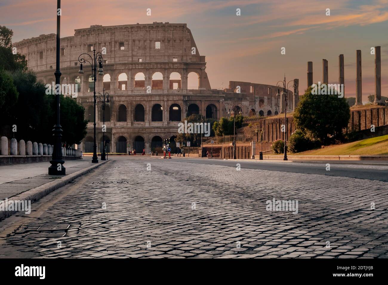 Via dei Fori Imperiali Straße in der Altstadt von Rom, Italien, völlig verlassen, mit dem Kolosseum im Hintergrund in den Farben o eingewickelt Stockfoto
