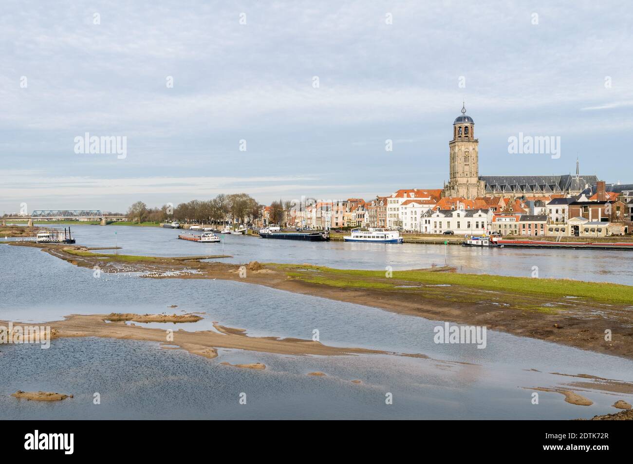 Deventer, NIEDERLANDE - 18. JANUAR 2014: Das historische Zentrum von Deventer mit der Lebuinuskirche und dem Fluss IJssel im Vordergrund. Stockfoto